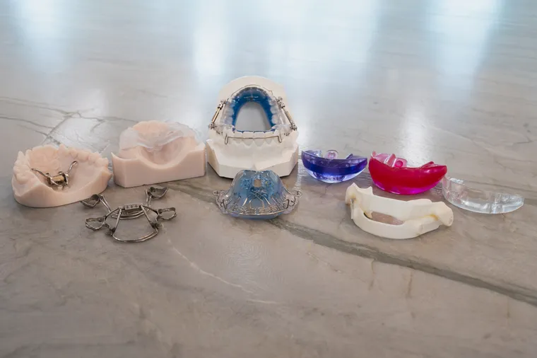 A lineup of custom oral appliances and expanders on a marble counter at Toothpillow Breathing & Sleep Center in Draper, Utah