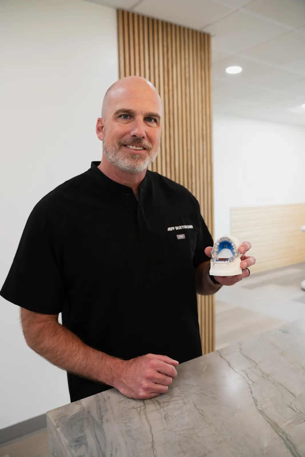 Dr. Jeff Buxton holding an airway expansion appliance on a dental model in Draper, Utah