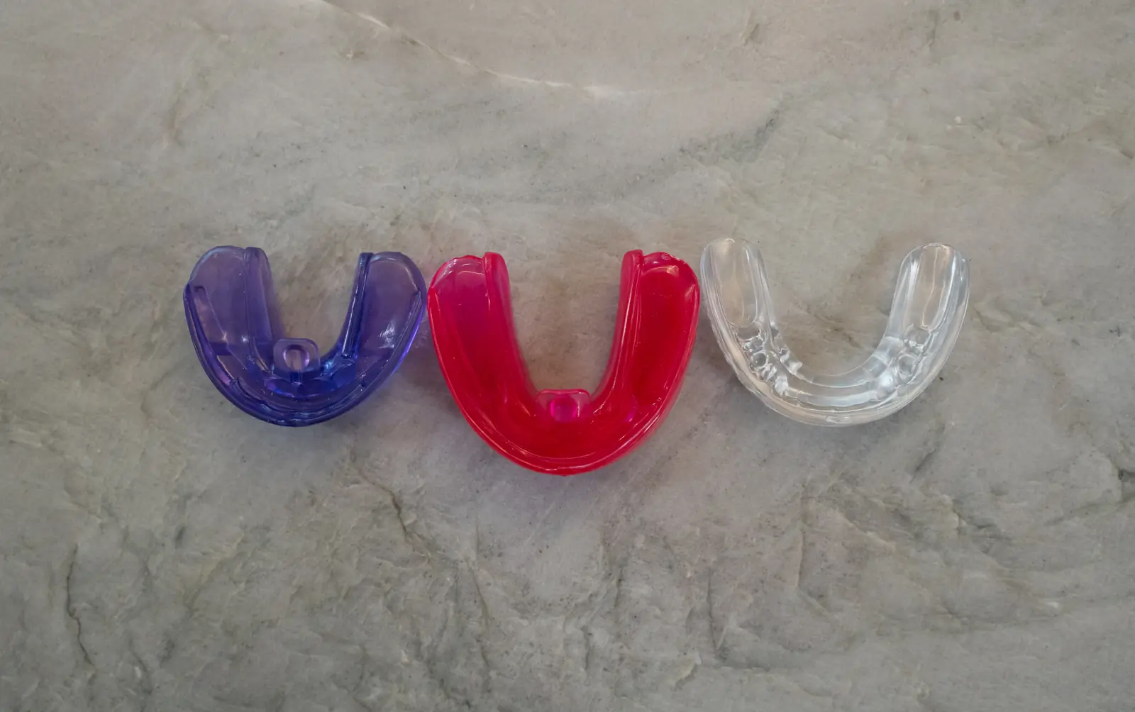 Soft removable oral trainers in purple, pink, and clear used for guided growth at Toothpillow Breathing & Sleep Center in Draper, Utah