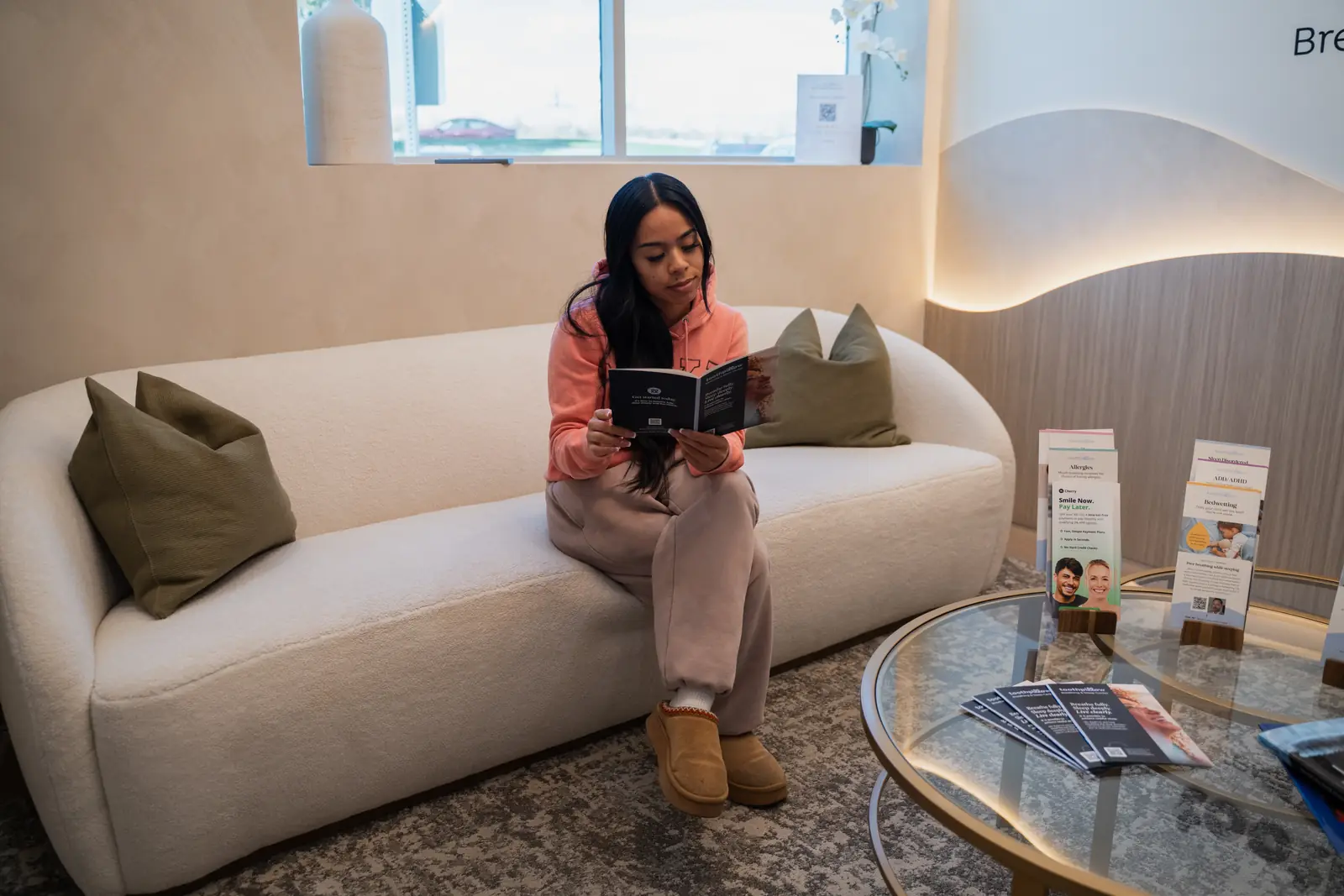 A patient reading information in the waiting room at Toothpillow Breathing and Sleep Center